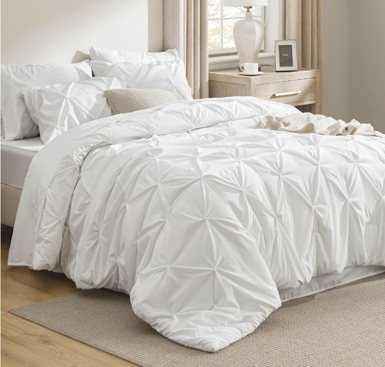 The Queen 7-Piece Pintuck Comforter Set is crafted from high-quality materials, designed to enhance your bedroom with soft luxury.