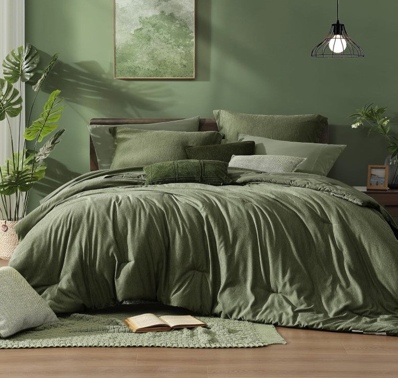 The olive green 7 piece bed in a bag set displayed on a twin bed with fresh linens and decor for a welcoming ambience.