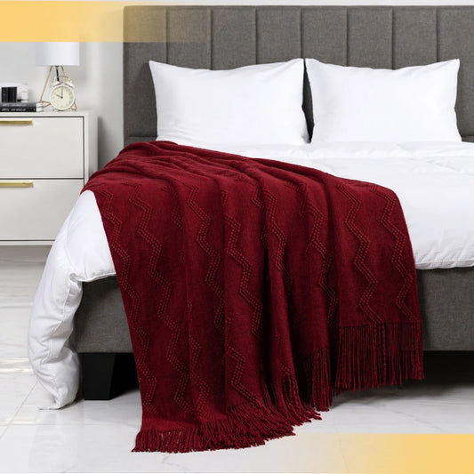 Soft textured burgundy throw blanket with chevron pattern and fringe, perfect for cozy couches and beds.