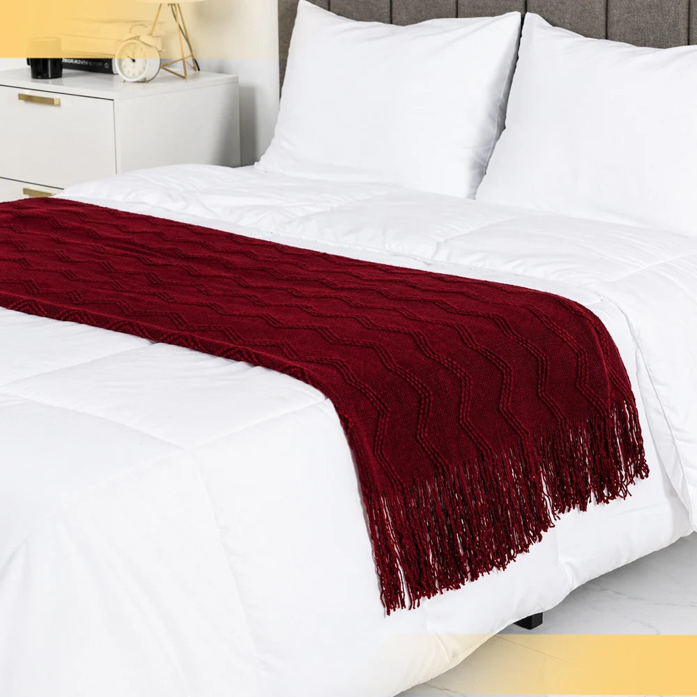 Burgundy throw blanket folded neatly on the edge of a bed, perfect for a stylish bedroom upgrade.