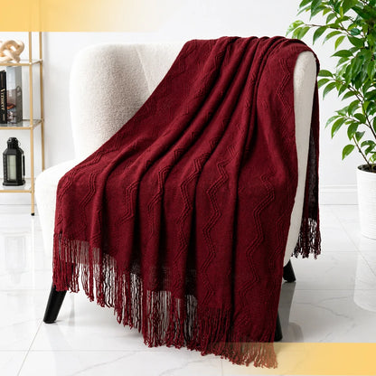 Cozy living room setup featuring a burgundy chevron throw blanket with fringe on a comfy armchair.
