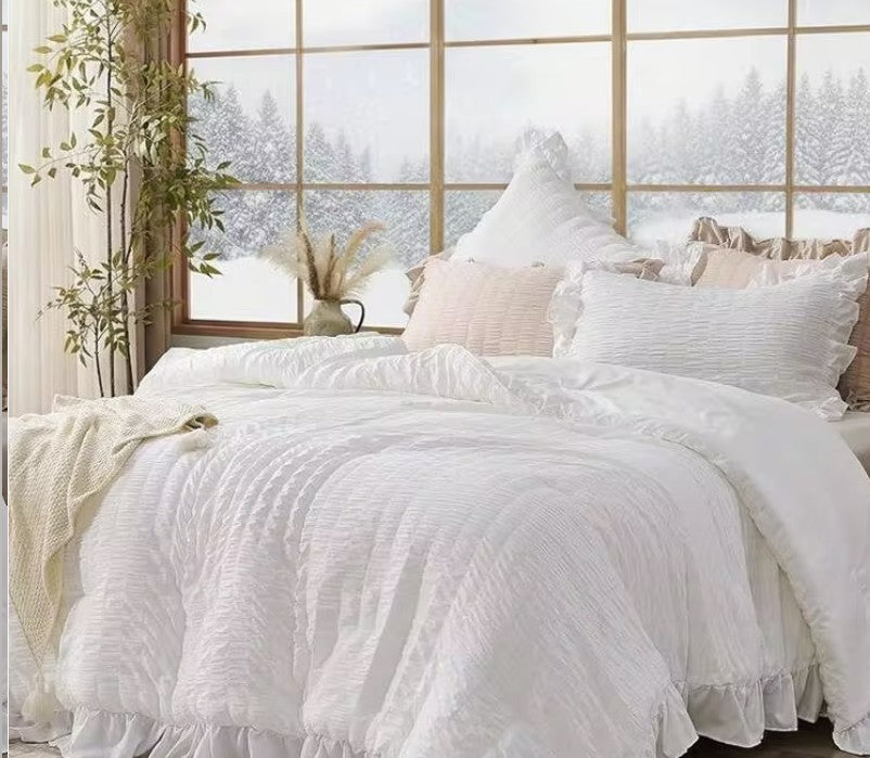 A styled bedroom featuring the White Ruffle Comforter Set paired with light wood accents, creating a serene environment.