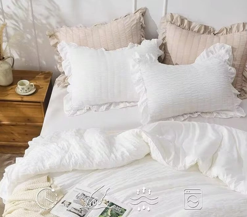 The luxurious feel of the White Ruffle Comforter Set shown with elegant decor elements for a boutique-style retreat.