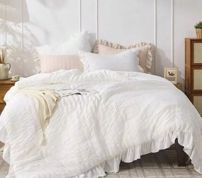 Stylish display of the White Ruffle Comforter Set against a backdrop of natural sunlight highlighting its softness.