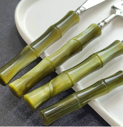Flatware Set of 5 pieces exhibiting the modern bamboo-style green acrylic handles on stainless steel cutlery, perfect for impressing guests at dinner parties.