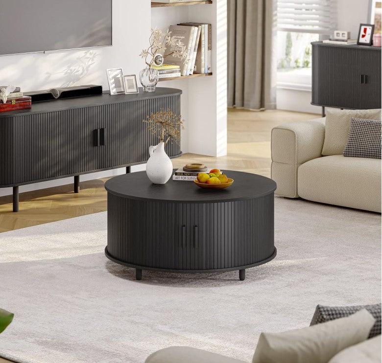 Black round mid century coffee table beside a sofa – A functional and decorative addition to living room spaces.
