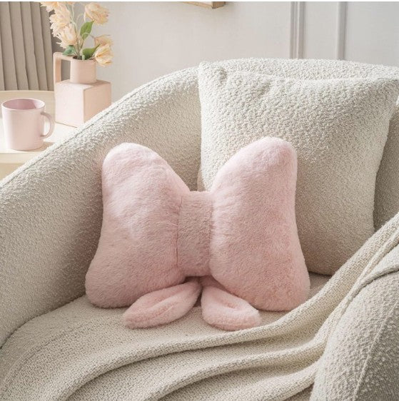Elegant pink bow throw pillow featuring a plush design, ideal for adding a feminine touch to any room.