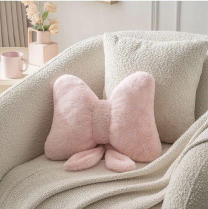 Elegant pink bow throw pillow featuring a plush design, ideal for adding a feminine touch to any room.