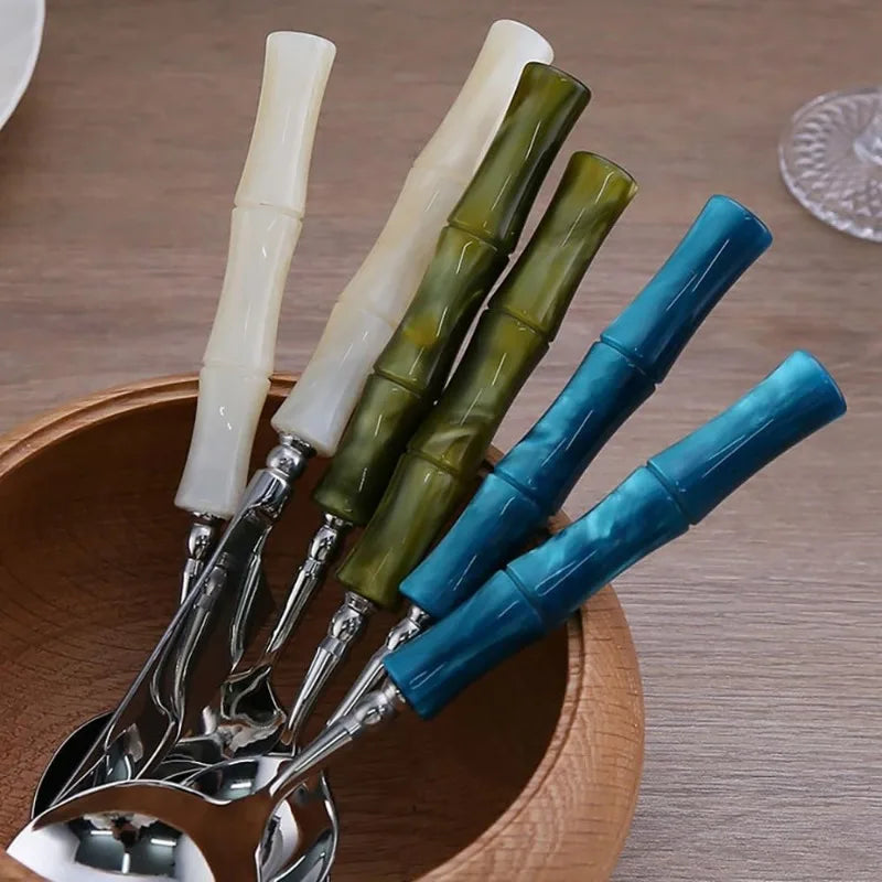Flatware Set featuring ergonomic bamboo-style green acrylic handles, showcasing the comfort and design of 18/10 stainless steel cutlery amidst elegant dinnerware.