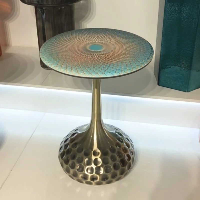Close-up of artisan top accent tables with brass bases, highlighting the craftsmanship and varied top designs each piece offers.