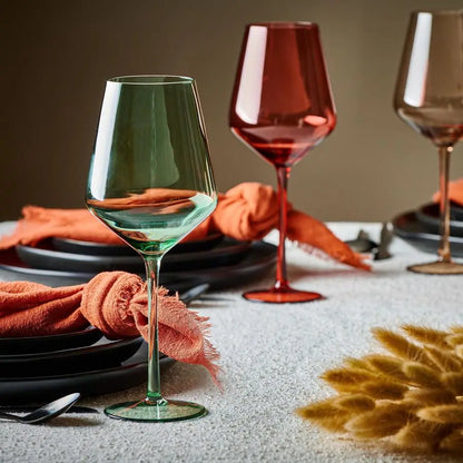Close-up view of vibrant pastel Art Deco wine glasses, highlighting the unique hand-blown designs and smooth grip.