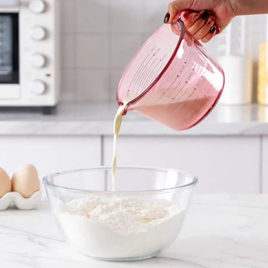 Set of pink glass measuring cups with easy-pour spouts, ideal for precise cooking and baking.