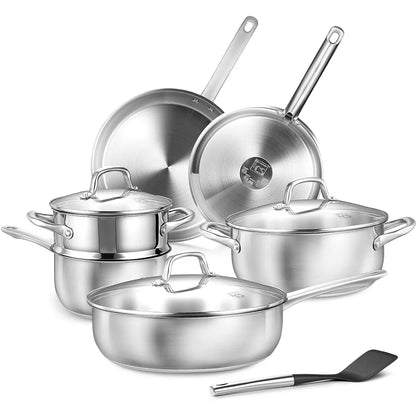 Set of stainless steel cookware with lids and a spatula on a white background