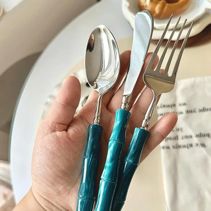 Various pieces of the Flatware Set displayed together including knife, fork, and spoon, all crafted from durable 18/10 stainless steel cutlery with vibrant green handles.