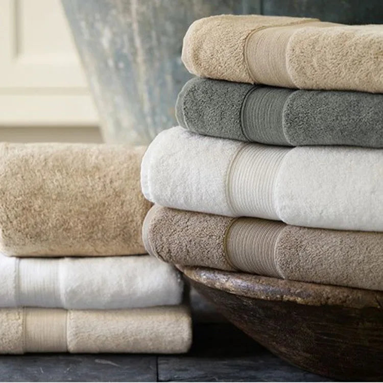 Ultra-Soft High-Absorbency Terry Bath Towel stacked neatly, showcasing different colors available in this lightweight luxury cotton design, ideal high absorbency bath towels.