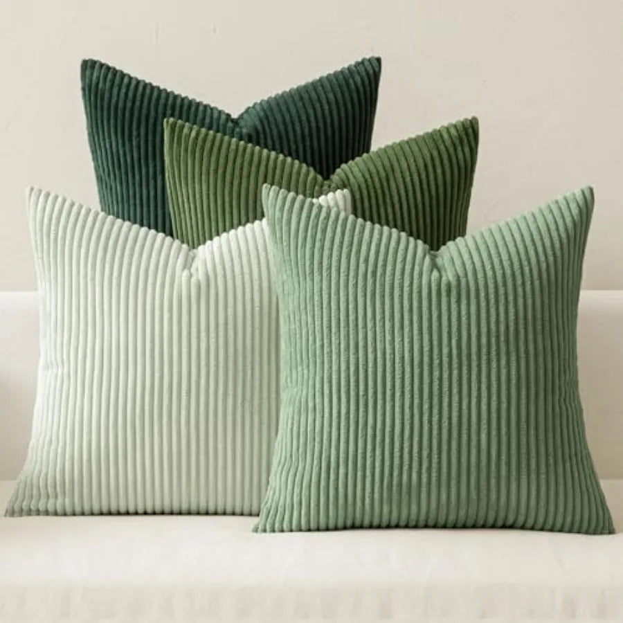 Set of green ribbed pillows on a neutral background