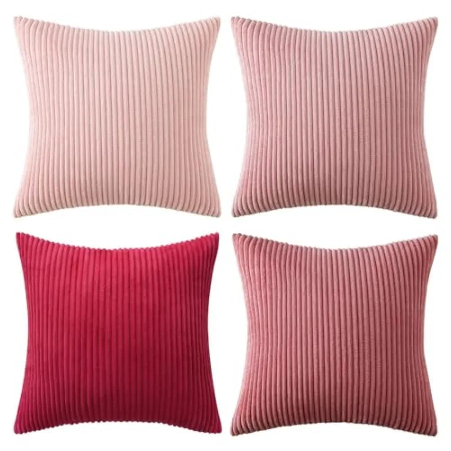 Four ribbed pink and red throw pillows on a white background