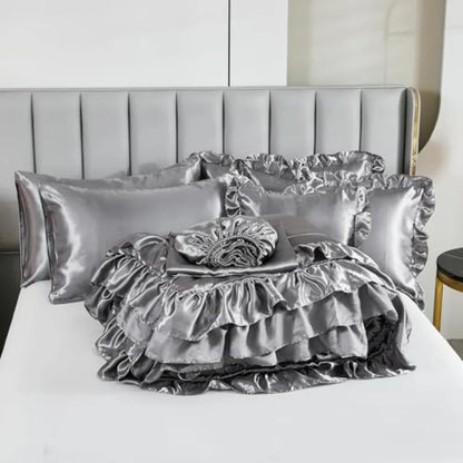 The Grey Satin Ruffle Comforter Set on a bed, accentuating its graceful and sophisticated look suitable for any modern bedroom.