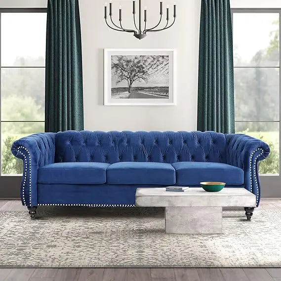 Blue Velvet Chesterfield Sofa – View of the 84" tufted 3-seater couch showcasing scrolled arms and button tufting in a living room setting.