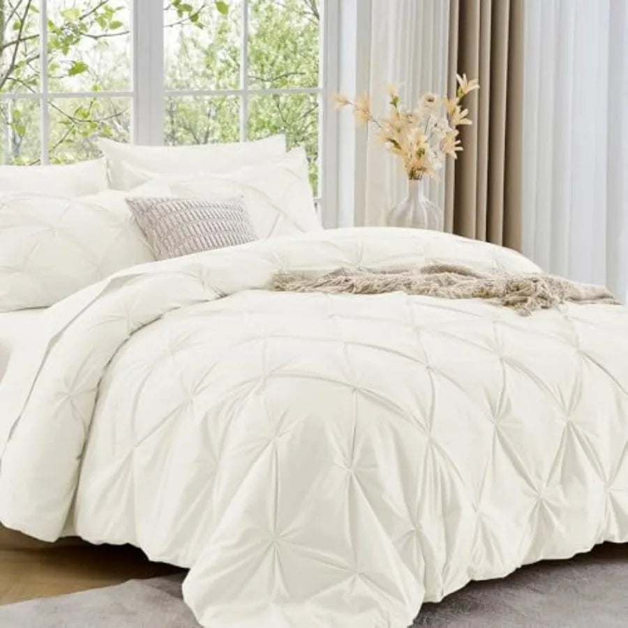 Elevate your bedroom with the Queen 7-Piece Pintuck Comforter Set, a luxurious bedding choice featuring pinch pleat detailing and all-season comfort.