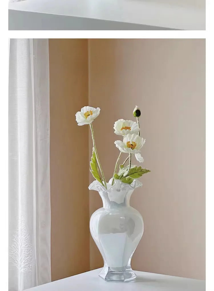 Overhead view of the Vintage 24Cm Opalescent Ruffled Edged Fenton Glass Vase among floral arrangements.