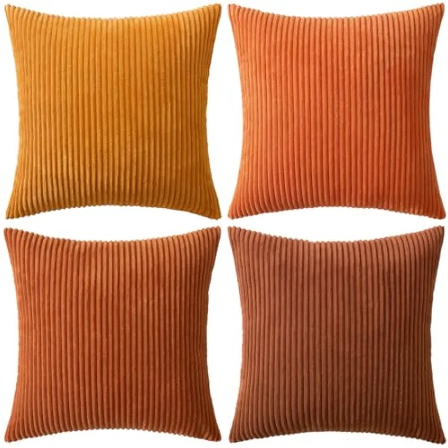 Four square ribbed throw pillows in warm autumnal shades of mustard yellow, burnt orange, terracotta, and rust brown, arranged in a 2x2 grid on a white background.