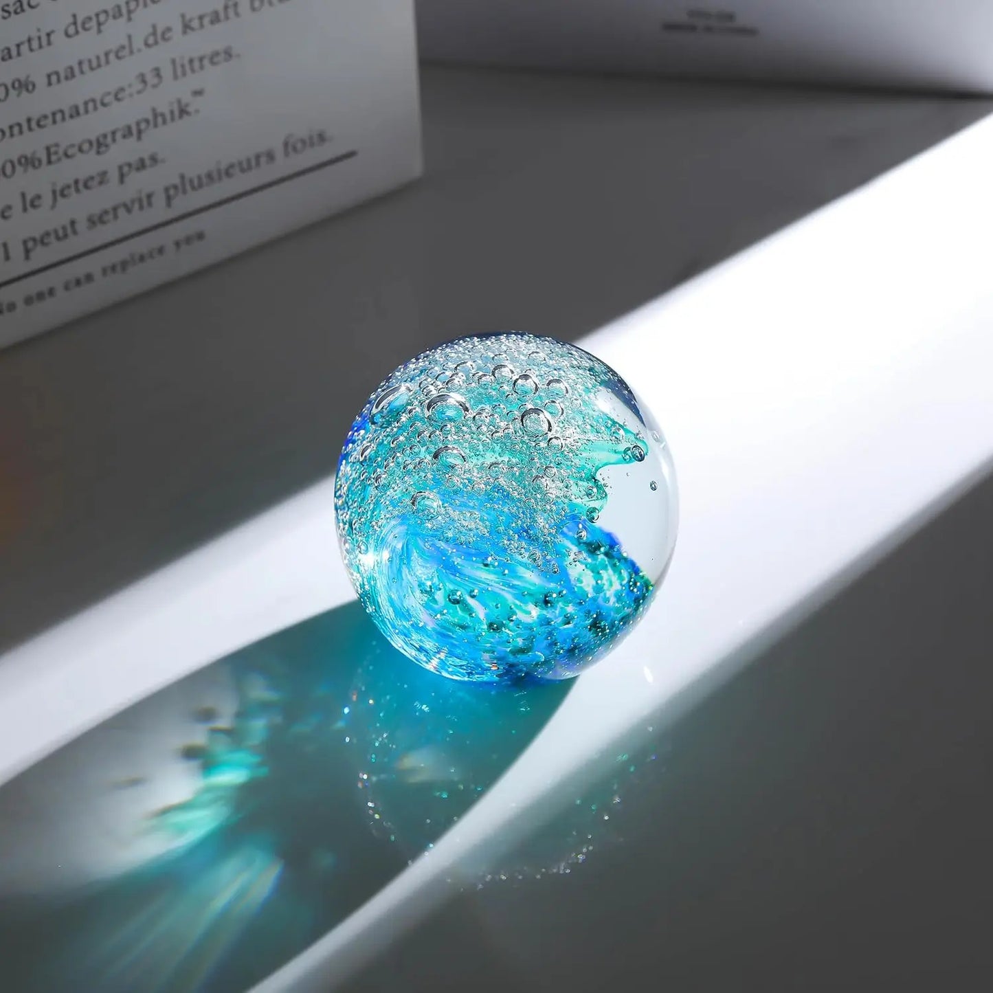 Close-up of the Hand-Blown Ocean Wave Glass Paperweight, capturing the intricate bubbles and details that mimic a real ocean wave.