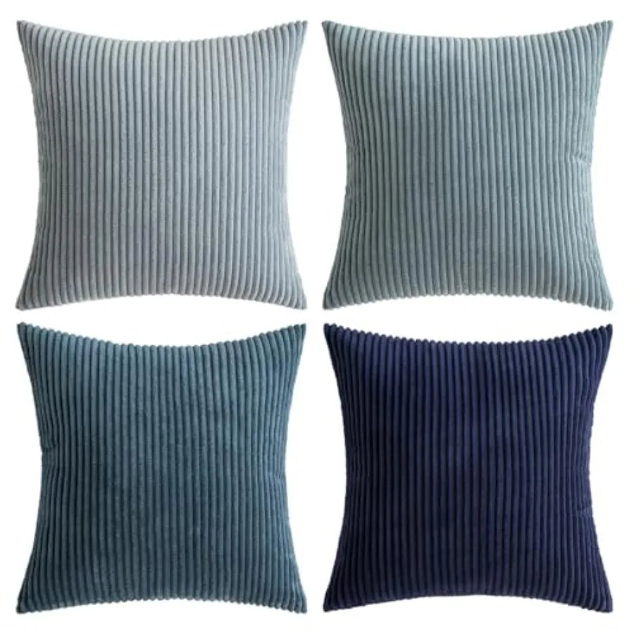 Four square ribbed throw pillows in shades of blue and navy, arranged in a 2x2 grid on a white background.