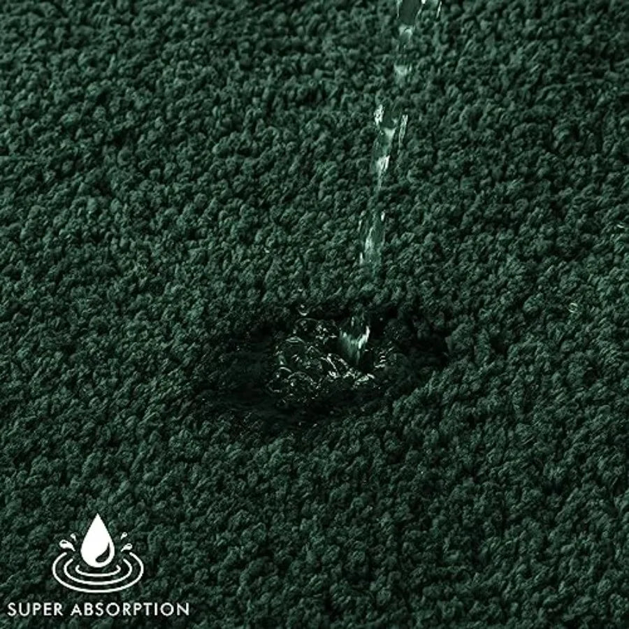 Dark green microfiber bath rug from the 2-Piece set featuring thick, tufted fibers for comfort.