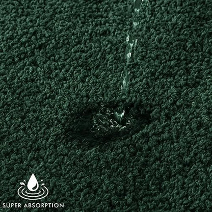 Dark green microfiber bath rug from the 2-Piece set featuring thick, tufted fibers for comfort.
