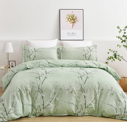 Sage green floral duvet surrounded by decorative pillows highlighting modern botanical theme.