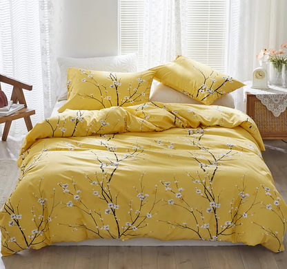 The sage green floral duvet cover set queen styled on a bed with yellow accent pillows.