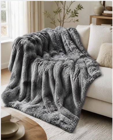 Cozy 50x60 Grey Faux Fur Sherpa Throw Blanket, Plush Reversible on a couch for warmth and style.